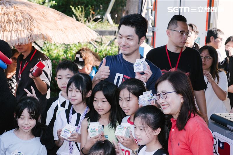 蔣萬安推廣「生生喝鮮乳」政策，與副市長林奕華和領到鮮奶的孩子們合影留念。(圖／記者楊士誼攝影)