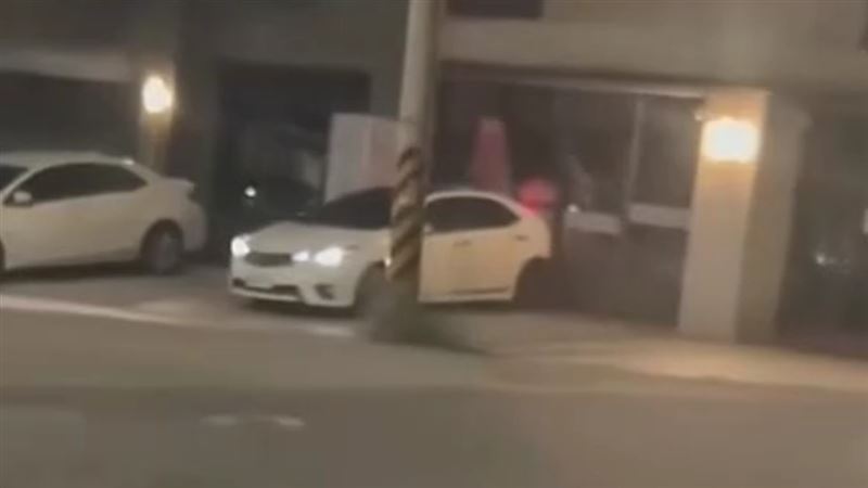 白色小客車倒車撞擊店家大門。（圖／翻攝自臉書）