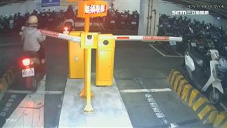 停車場驚險！騎士跟太近　遭柵欄打中重摔