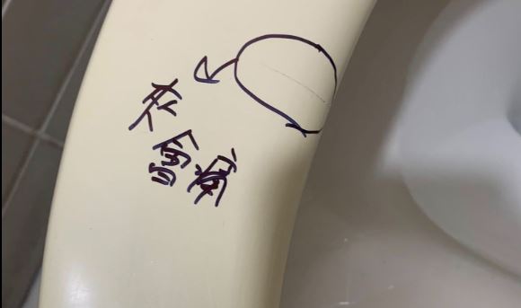 網友分享，在公廁意外發現馬桶坐墊上被畫上一個圈圈，旁邊還寫著三個斗大字「夾會痛」。（圖／翻攝路上觀察學院）