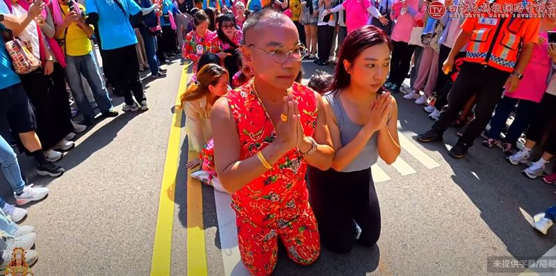 胡漢龑率親友身穿招牌「東北大花」服跪地接駕，並不斷高喊「媽祖！媽祖！我愛你！」全家人依序鑽轎底領福。（圖／翻攝白沙屯媽祖網路電視台）