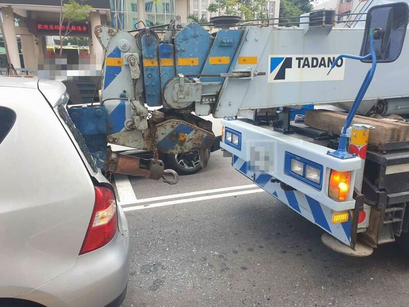 大吊車吊臂直接撞上前方轎車的後擋風玻璃。（圖／翻攝畫面）