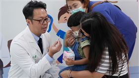 北醫附醫兒科部張璽主任(左)為小朋友及家長解說鼻噴式流感疫苗的操作。（圖／北醫附醫提供）