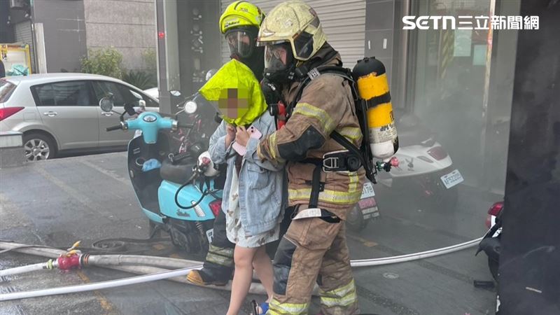 有一名女住戶，在搜救人員協助下頭套「共生面罩」脫困。（圖／翻攝畫面）