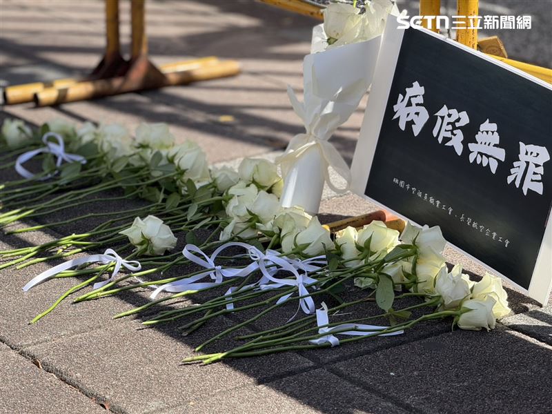 立院前的白玫瑰與手牌「請假無罪」。（圖／記者李育道攝影）