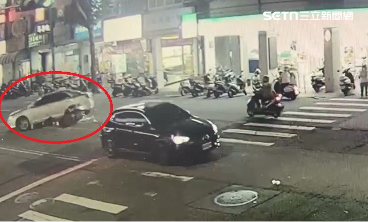 轎車鬼切迴轉，後方騎士反應不及發生碰撞，連人帶車衝進車底受困。（圖／翻攝畫面）