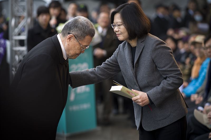 2017年2月28日，時任總統蔡英文出席二二八事件70周年中樞紀念儀式，從受難者家屬潘信行手中接過《二二八事件責任歸屬研究報告》。（圖／翻攝維基百科）