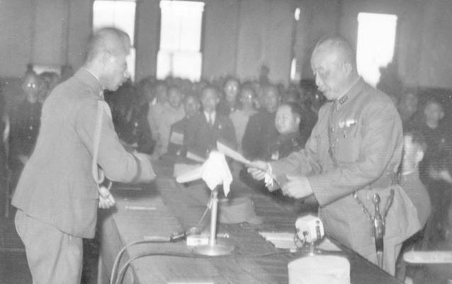 1945年10月25日，陳儀（右）代表國民黨政府接手台灣，在台北公會堂接受大日本帝國第10方面軍司令官安藤利吉所簽名蓋章的受領證，經由第10方面軍參謀長諫山春樹（左）轉交給陳儀。（圖／翻攝維基百科）