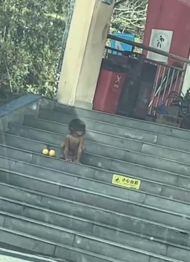 赤裸男童像動物一樣，趴伏在台階上觀望。（圖／翻攝自微博）