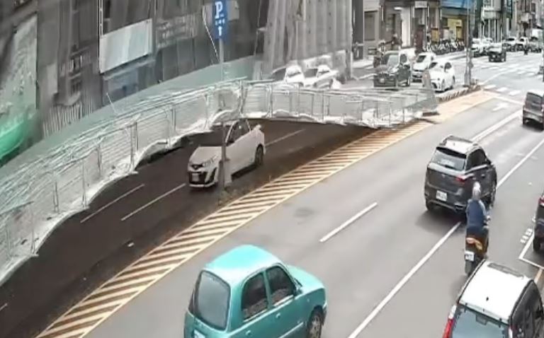 白色轎車經過時恰巧遭鷹架「吞噬」。（圖／翻攝自 Threads @azzz30678）