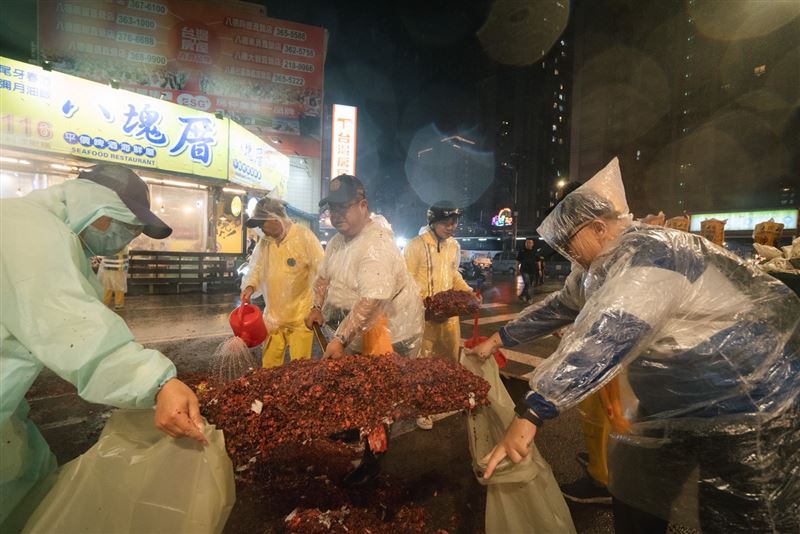 志工與清潔人員在大雨中努力收拾沿途的鞭炮與垃圾。（圖／桃園護國宮提供）