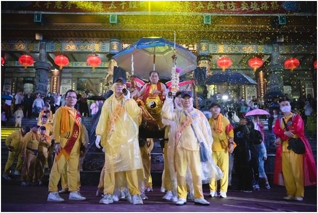 桃園護國宮太子爺「五夜暗訪」風雨中回鑾,太子爺在閱兵台上陣頭一一參禮,頭家們和貴賓扛著釘椅恭迎聖駕。(圖/桃園護國宮陳乃瑋攝影)