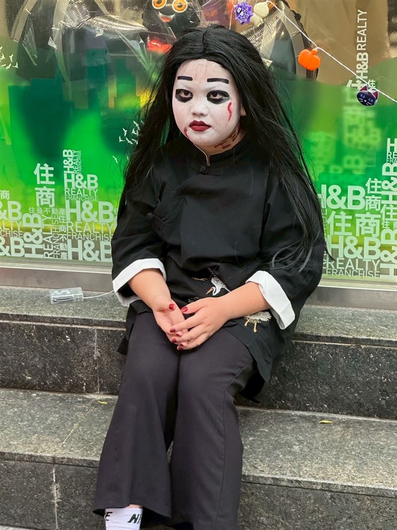 走累了的小鬼，坐在路邊一臉生無可戀（圖／住商不動產五泰房屋提供）