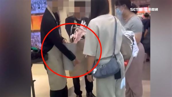 店員拿抽獎箱吸引小朋友抽獎換禮物