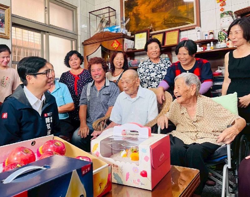 高雄市長陳其邁(前排左1)去年赴田寮區慰訪百歲人瑞夫妻,各致贈新台幣1萬元重陽敬老禮金,並代表衛生福利部頒贈金鎖片,祝福兩人健康長壽。(高雄市政府社會局提供)