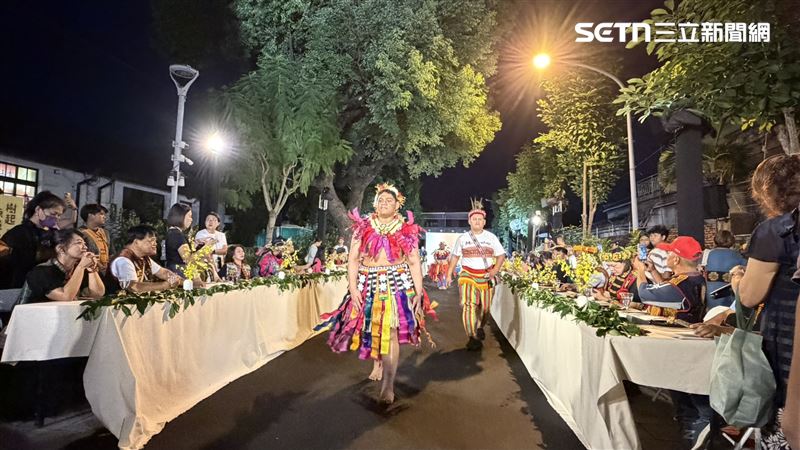 西式白長桌蔓延數尺，夾道出天然伸展台，一雙雙裸足踏上黑地毯，邁出自信、自我認同步伐，傳統服飾在燈光下色澤、韻味展露無疑。（圖／記者簡榮良攝影）