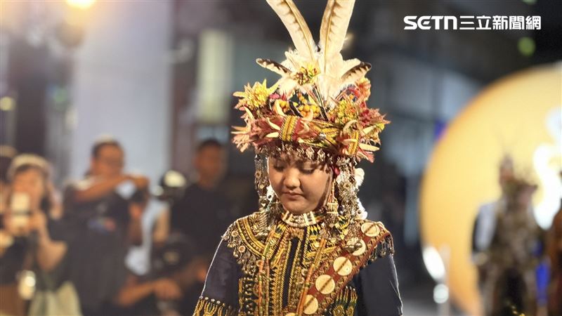 西式白長桌蔓延數尺，夾道出天然伸展台，一雙雙裸足踏上黑地毯，邁出自信、自我認同步伐，傳統服飾在燈光下色澤、韻味展露無疑。（圖／記者簡榮良攝影）