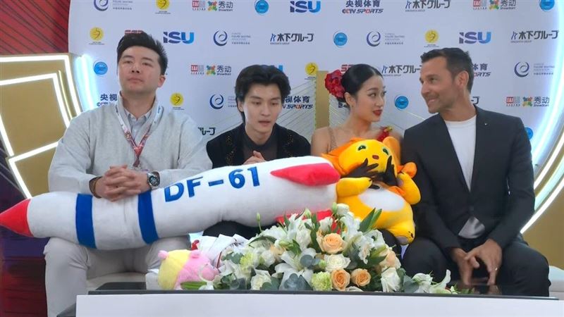 中國選手任俊霏（左2）、邢珈寧（右2）25日在國際滑冰總會花式滑冰大獎賽中國盃賽事展示東風61型飛彈玩偶。（圖／翻攝自Golden Skate推特）