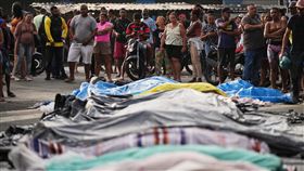 巴西警方28日在里約熱內盧貧民窟掃蕩毒梟，29日清晨超過50人陳屍街頭，居民將數十具遺體排放街頭。（圖／美聯社／達志影像）