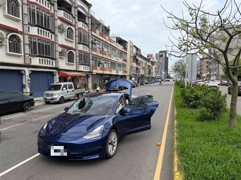 特斯拉擋風玻璃撞出一個大洞，車旁還遺落一顆老夫妻提著的橘子。（圖／翻攝畫面）