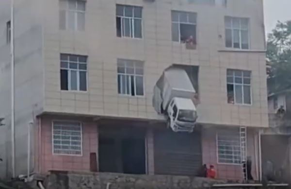 中國湖北一輛貨車撞破2樓牆面，掛在半空中搖搖欲墜，嚇壞民眾。（圖／翻攝微博）