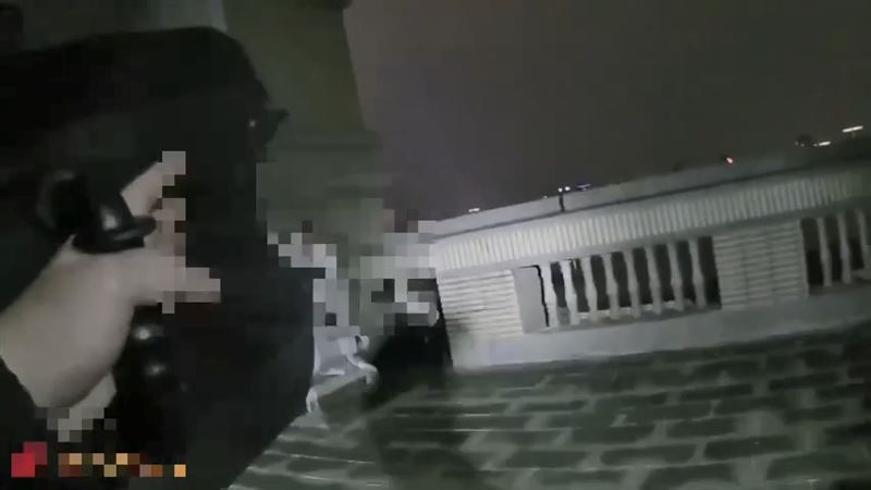 嫌犯挾持妹妹到社區15樓頂樓與警方對峙，員警勸說犯嫌不要輕舉妄動。(圖／翻攝畫面)
