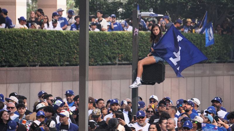 道奇冠軍遊行　球迷擠爆街頭美國職棒洛杉磯道奇隊連2年奪世界大賽冠軍，3日舉行封王遊行，25萬人擠爆洛杉磯街頭，有人爬上交通號誌、電線桿只為了一睹球星風采。（圖／中央社）