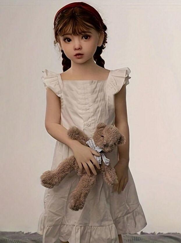 該玩偶是一個綁著雙辮的女童，穿著類似睡衣的連身裙，手中還抱著一個泰迪熊。（圖／翻攝自Shein官網）