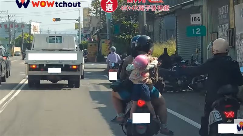 高雄市燕巢區昨天有一對夫妻騎機車載小孩，四貼上路，但因機車座位被父母擠滿，在後面的小孩宛如「後背包般」雙腳懸空被吊在後方並在車陣中行駛。（圖／翻攝自WoWtchout - 地圖型行車影像分享平台）