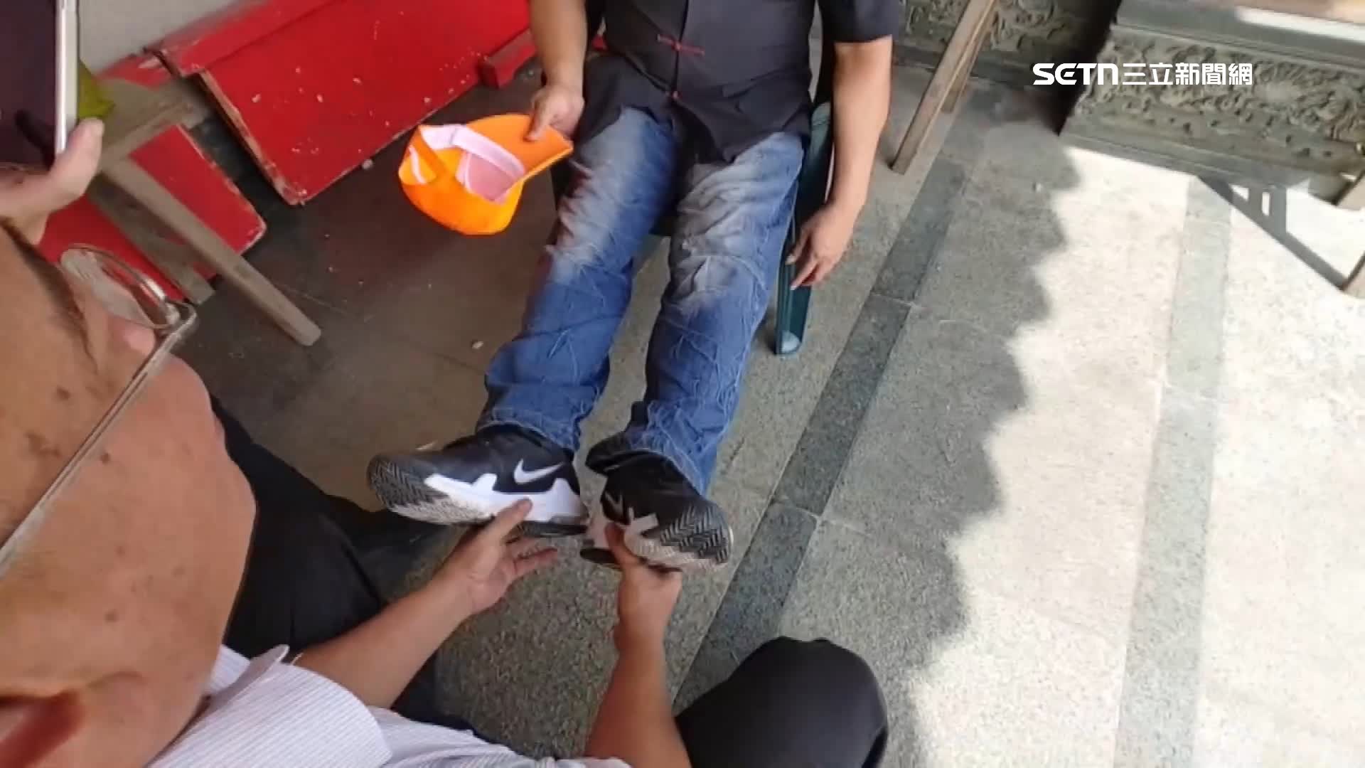 吳先生雙手捧著民眾的腳