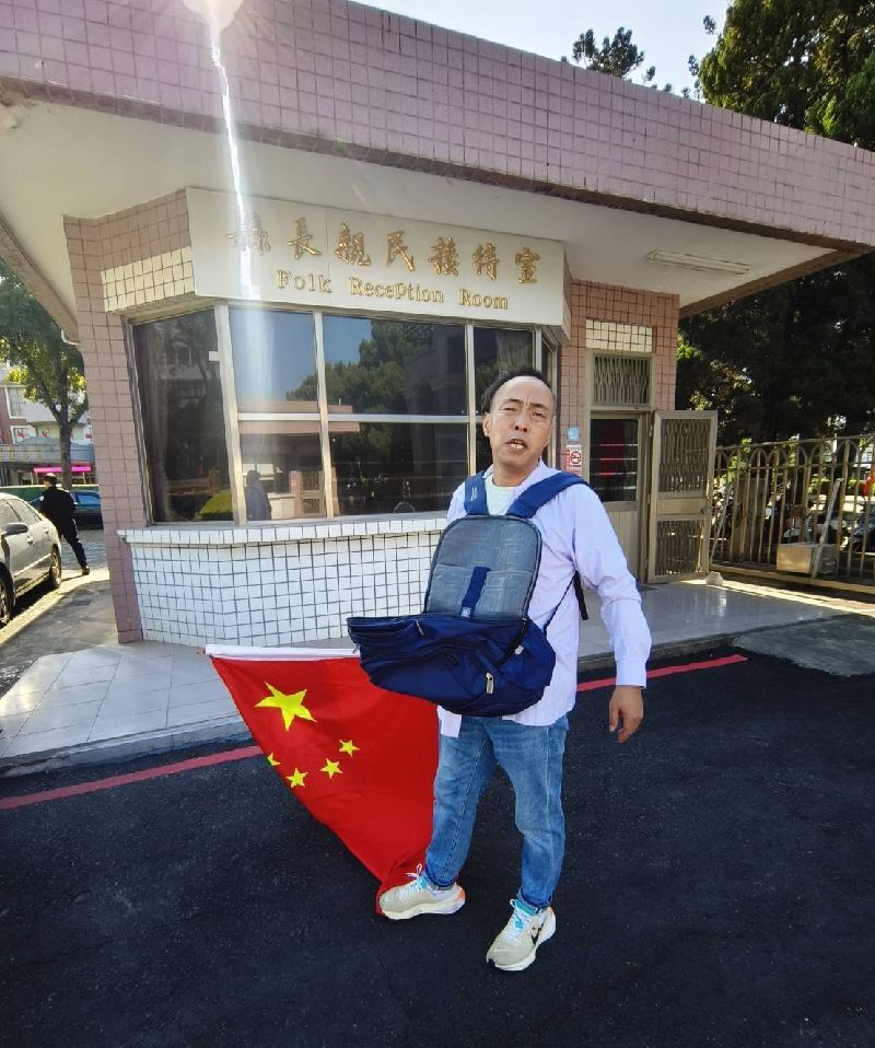 1名中國籍男子持五星旗至金門縣政府前，並撒播寫有「統一台灣」等語傳單。（圖／中央社）