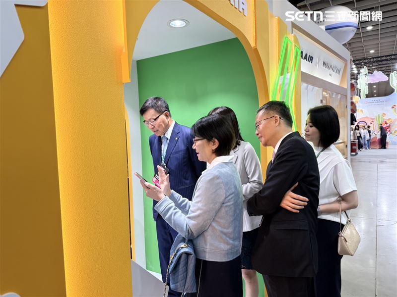 長榮航董座林寶水與總經理孫嘉明展前在攤位上玩拍貼機。(圖/記者李育道攝影)