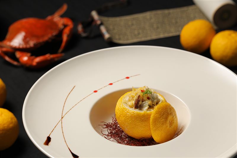 「蟹釀橙」主廚在挖空的香橙中填入鑊氣滿滿的蟹料，果香與蟹香交融，香氣馥郁、滋味鮮美。（圖／飯店旅宿業者提供）