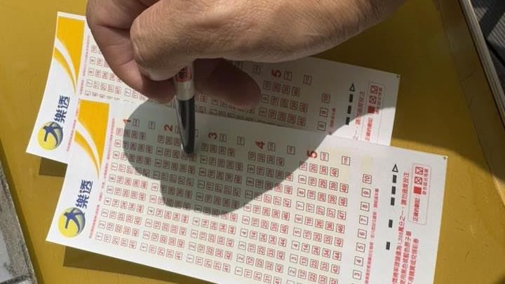 大樂透連16槓，頭獎上看6.7億，晚間彩券行排爆！彩迷包牌、機選、合買全上陣，群組分紅洗版。財政部提醒合買先寫集資單、留存憑證，分紅逾244萬須申報贈與稅。理性下注、憑證留好。截止前把握時段，祝好運衝破第16槓平安發財。（圖／記者師瑞德攝影）