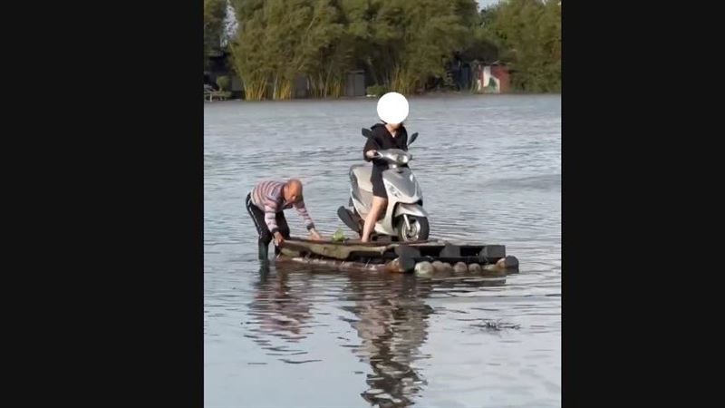 宜蘭五結鄉利澤村淹大水，一名護理師出門上班用竹筏幫忙拖載機車。（圖／翻攝畫面）