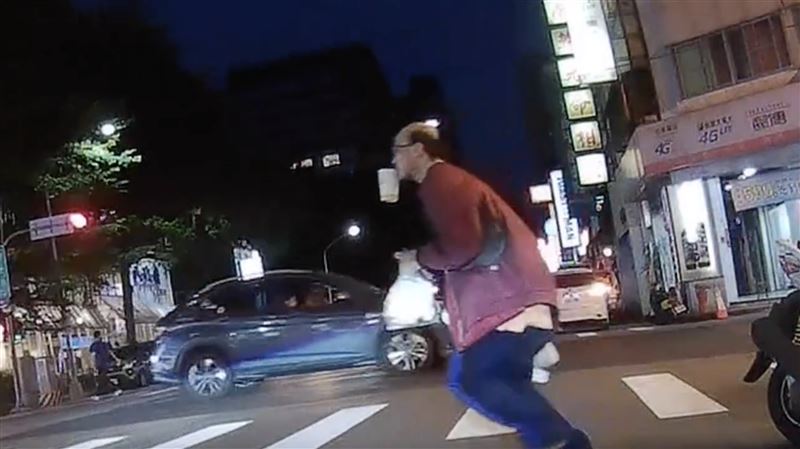 謝男偷走筆電包後又快步衝向對向馬路後消失在人群中。（圖／翻攝畫面）