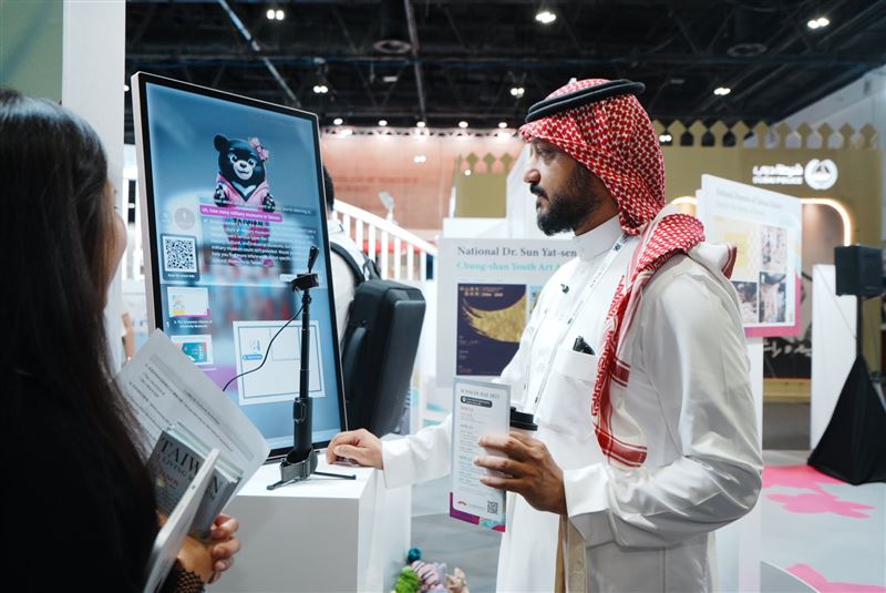 國際友人前來體驗臺灣館的AI導覽機，與臺灣黑熊AI助理一貝兒互動，認識臺灣各個博物館（圖／中華民國博物館學會提供）