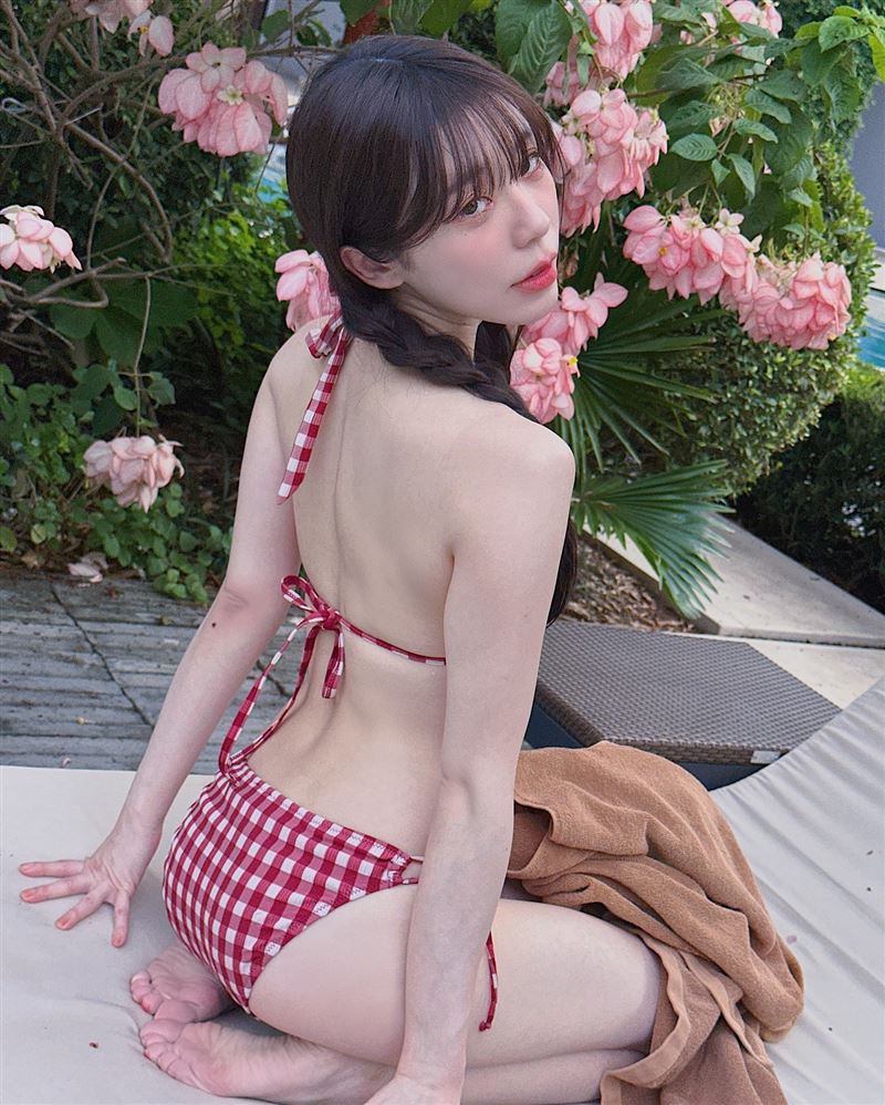 赤鬼伯伯身穿紅色格紋比基尼，在泳池邊擺拍，性感雪白好身材呼之欲出。（圖／翻攝自赤鬼伯伯臉書）