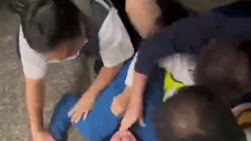 列車長及站務員要求男子下車，但男子卻情緒激動，先是坐在地上大聲咆哮，之後更用腳踹攻擊副站長、站務員。（圖／讀者提供）