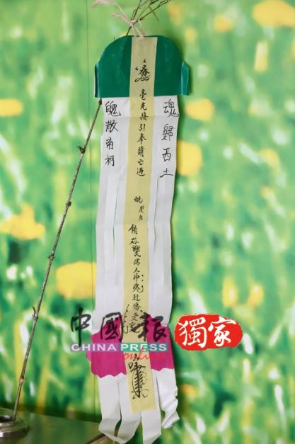 網紅謝侑芯16日於馬來西亞火化，簡易靈堂擺著牌位、招魂幡及飯菜，未見遺照。圖為招魂幡。（圖／《中國報》提供）