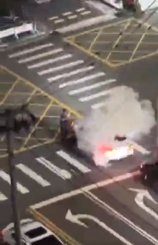 陳姓男子（灰衣）持滅火器驅離炸街改裝車，不料竟遭球棒隊圍毆。(圖／翻攝自記者爆料網)