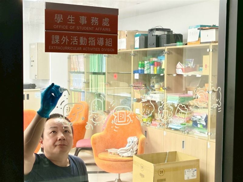 藝術家大石曉規在全人教育大樓窗面繪製微笑角色。（圖／長庚科大提供）