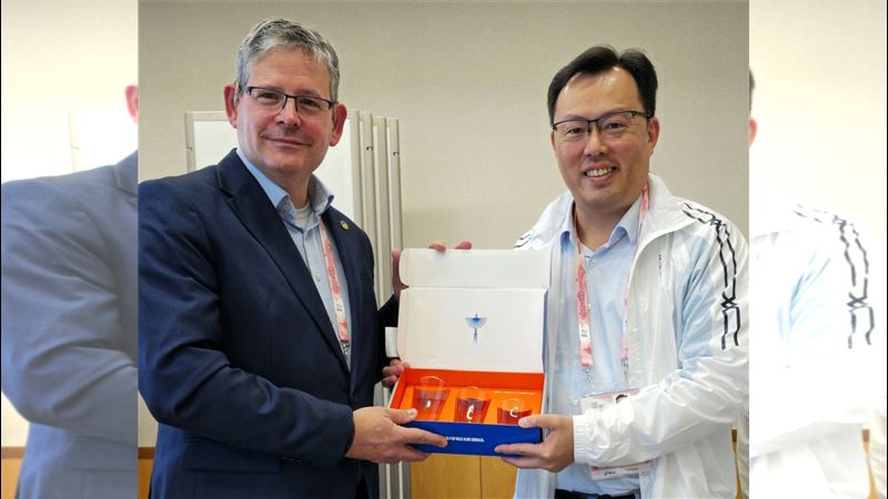 運動部鄭世忠政務次長（右）致贈臺灣藍鵲玻璃杯予國際聽障運動總會Ad&aacute;m K&oacute;sa主席(左)，藉藍鵲群居的特性表達臺灣也是國際聽障運動總會大家庭的一員，將與會員國夥伴們一同推動聽障運動。(圖／運動部提供)