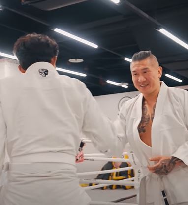 黃國昌（左）健身滿一年，來找館長（右）練柔術驗收成果。（圖／翻攝自飆捍臉書）