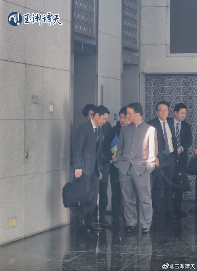 畫面左前方男子為金井正彰，右方為劉勁松，在送客時雙手插袋。(圖/翻攝微博)