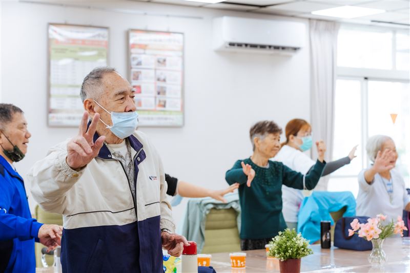 兩廳院推動「藝術出走」計畫，日照中心長輩隨老師的帶領，開心的做出演唱歌仔戲的動作。（圖／兩廳院提供）