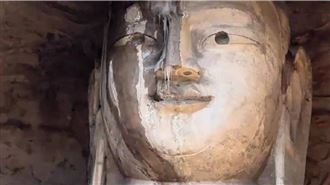 雲岡石窟佛像的眉骨與鼻樑處懸掛著細長冰凌，遠看宛如大佛因受寒而「流鼻涕」。（圖／翻攝自《百度》）