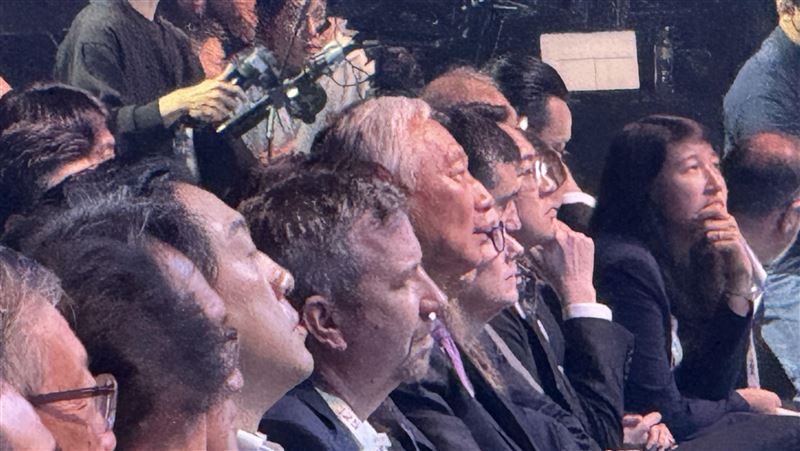 郭台銘時隔3年重返鴻海科技日，服喪期白髮現身、未致詞僅鞠躬致意，劉揚偉開場感謝其創業打底與支持。郭全程台下聽講並與劉低聲交流，畫面對比2021首屆科技日他生日駕Model E登場、宣示MIH電動車雄心，象徵精神續航再起。（圖／記者師瑞德攝影）