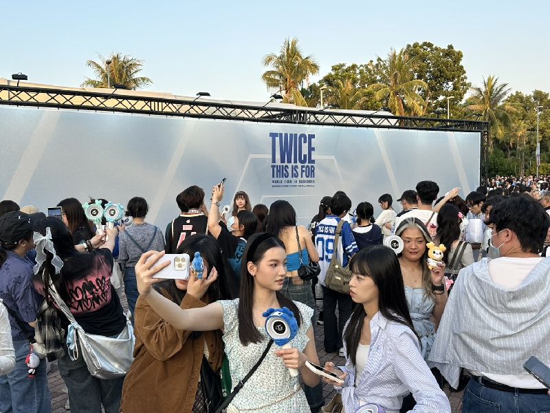 韓團TWICE於22日晚間將登高雄國家體育館（世運主場館）開唱，吸引萬名粉絲朝聖，開唱前，場外粉絲聚集在大型看板處拍攝合影