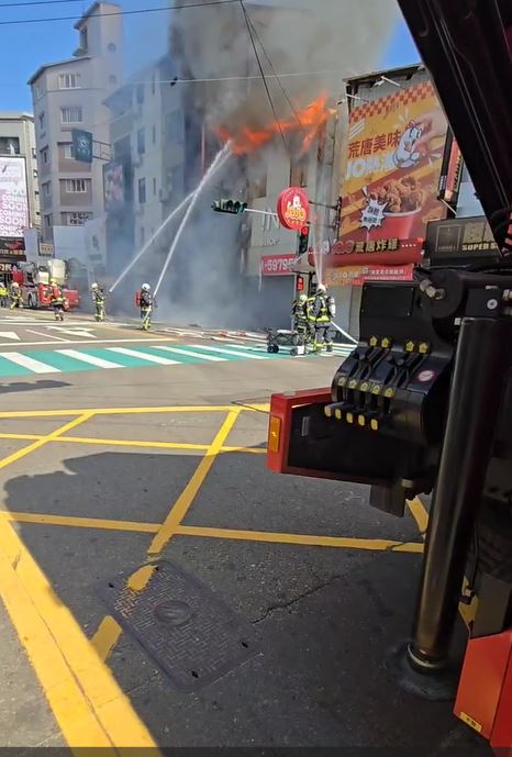 其中一間店面外牆不堪高溫，整片崩塌差點砸中消防員。(圖／翻攝畫面)